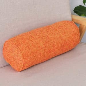 Coussin cylindrique orange posé sur un canapé.