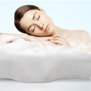 Femme accoudée sur un oreiller blanc avec de la brume blanche qui sort de l'oreiller
