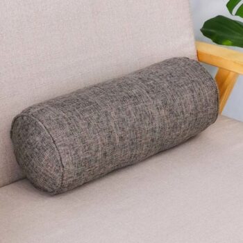Coussin cylindrique gris posé sur un canapé.