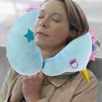 Femme utilisant un coussin bleu en forme de U et de licorne.