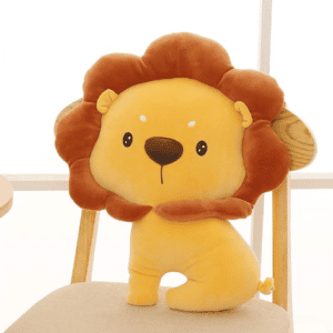 Joli coussi en forme de lion jaune et marron. Il est posé sur une chaise.