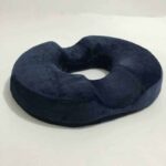 Coussin ovale bleu avec un trou au milieu sur fond blanc.