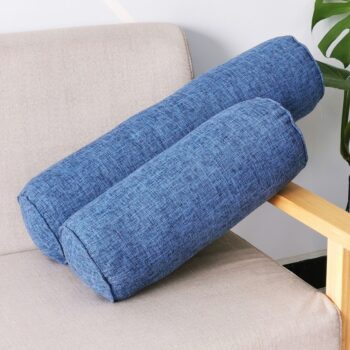 2 coussins cylindriques bleus de taille différente posés sur un canapé.