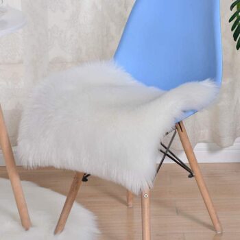 Coussin blanc plat posé sur une chaise bleue.