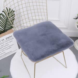Coussin gris carré posé sur une chaise