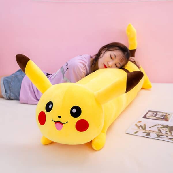 femme allongée sur le ventre, repose sa tête sur le coussin Pikachu jaune, long et de forme cylindrique