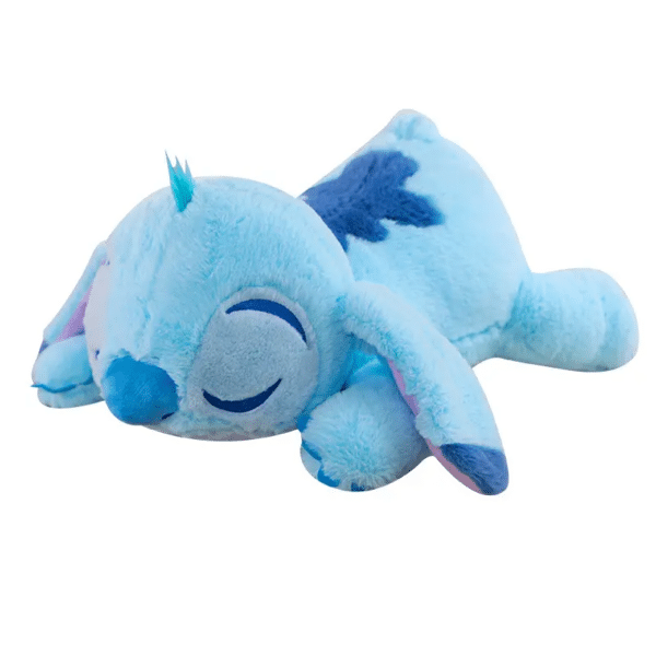Coussin peluche Stitch bleu en train de dormir sur un fond blanc