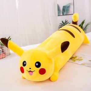 Coussin Pikachu jaune, long et de forme cylindrique avec bouche ouverte posé sur une table à manger