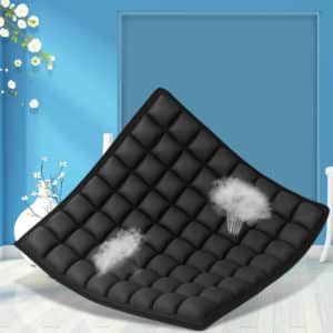 Coussin carré noir avec des petits coussinets et des nuages d'air qui sortent du coussin. Le fond de la pièce est bleu avec un vase blanc et des fleurs blanches
