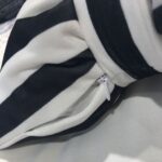 une partie d'un coussin noir et blanc en forme de nœud