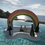 coussin flottant arc-en-ciel dans une piscine avec des bouteilles