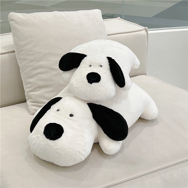 coussins noir et blanc en forme de chien posés l'un sur l'autre et tout deux sur le canapé