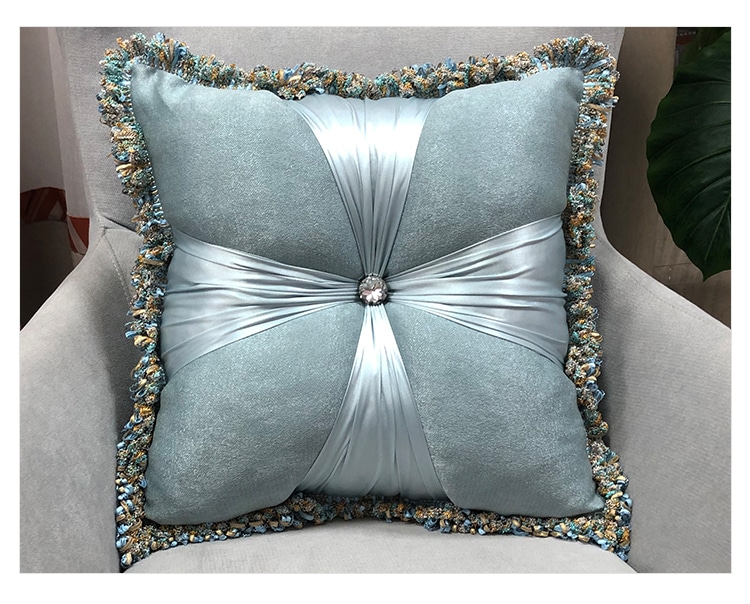 Coussin carré en velours et en lin gris à motif de fleur posé sur un canapé