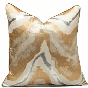 Joli coussin avec une housse dorée, blanche et grise. Tons naturels. Imitations traces d'eau