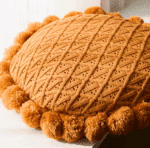 Très joli coussin en tricot, mailles, crochet, à pompon, terracotta.