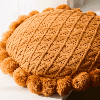 Très joli coussin en tricot, mailles, crochet, à pompon, terracotta.