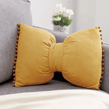 Très joli coussin de 30x50 cm en forme de nœud. Couleur ocre.
