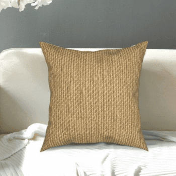Très jolie housse de coussin en toile de jute 45x45 cm, le coussin est posé sur un canapé.
