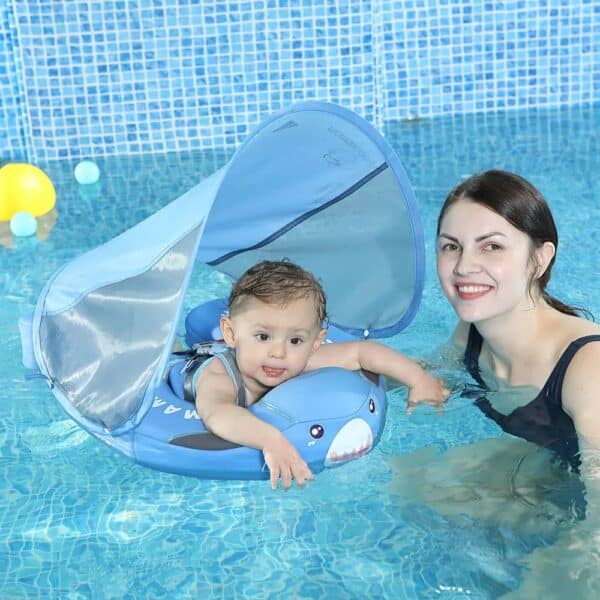 Bébé dans une bouée solide de natation flottante et sa mère à côté de lui dans une piscine