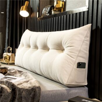 Coussin tête de lit blanc en position debout présent dans une chambre et positionné sur un lit. Le coussin tête de lit blanc a une poche sur la gauche, à lintérieur de cette poche il y a un téléphone portable.