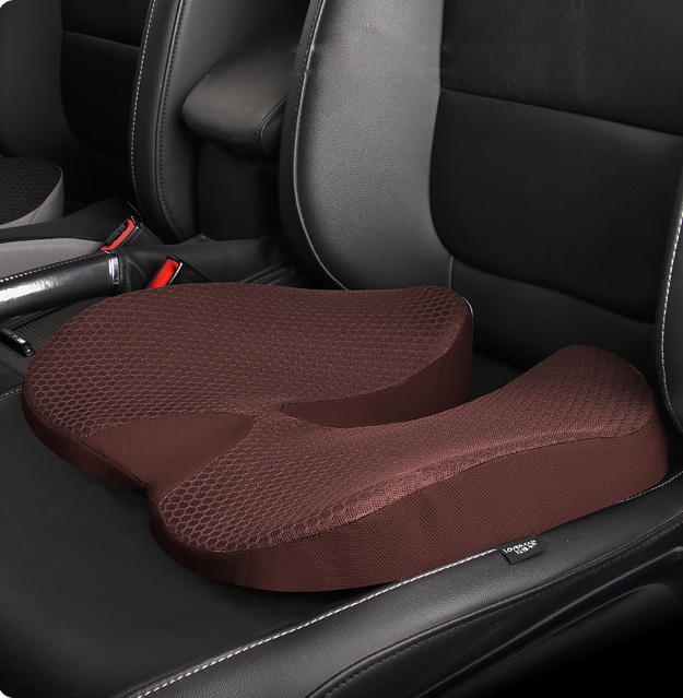 Coussin hémorroïdes confort de couleur marron posé sur un siège automobile