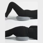 Femme assise les deux fesses sur un coussin rond gonflable gris et assise sur le côté