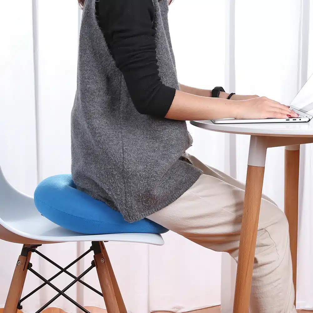 Une personne assise sur le coussin bleu ciel posé sur une chaise blanche