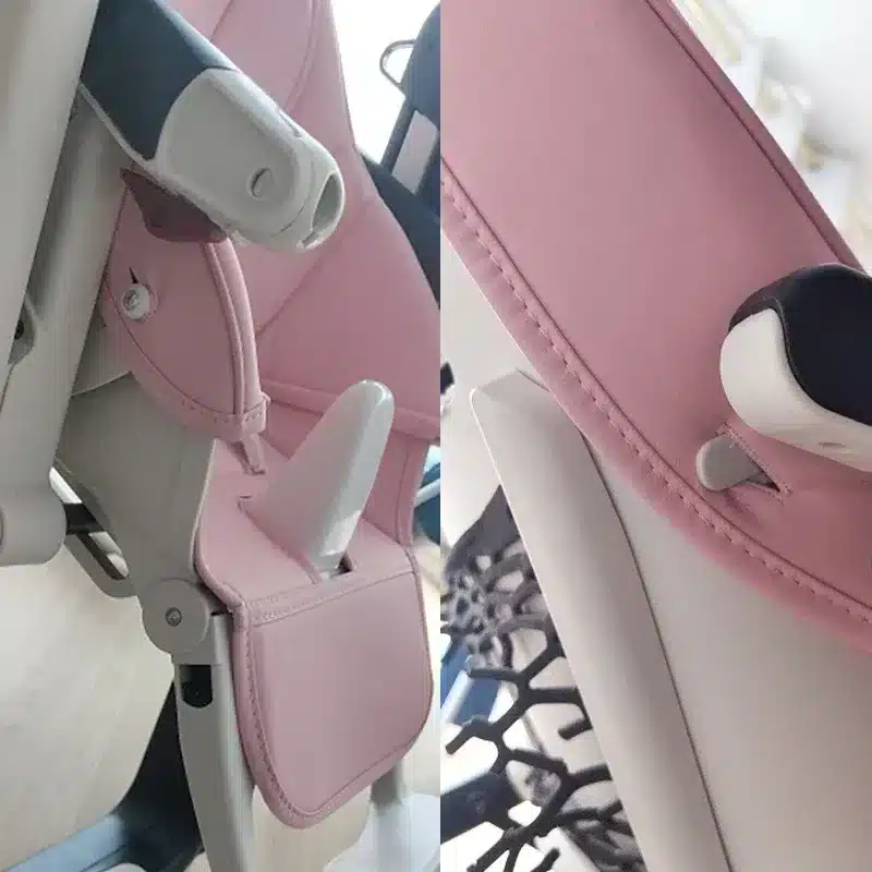 Coussin de chaise en cuir (Peg Perego Prima Pappa Zero3) de couleur rose posé sur une chaise haute blanche et grise foncée. Vu de côté et vu sur la fente permettant de fixer le coussin à la chaise.