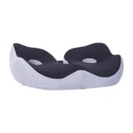 Coussin de siège ergonomique de couleur noir en forme de U avec deux trous d'aération et une bande élastique équipée d'une fermeture à boucle pour adapter la taille du coussin à vos fesses. Le coussin est visible de face.