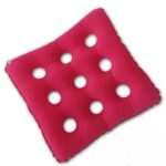 Coussin gonflable anti-escarre de couleur rouge, posé en biais, conçu avec une structure en grille comprenant 9 trous circulaires.
